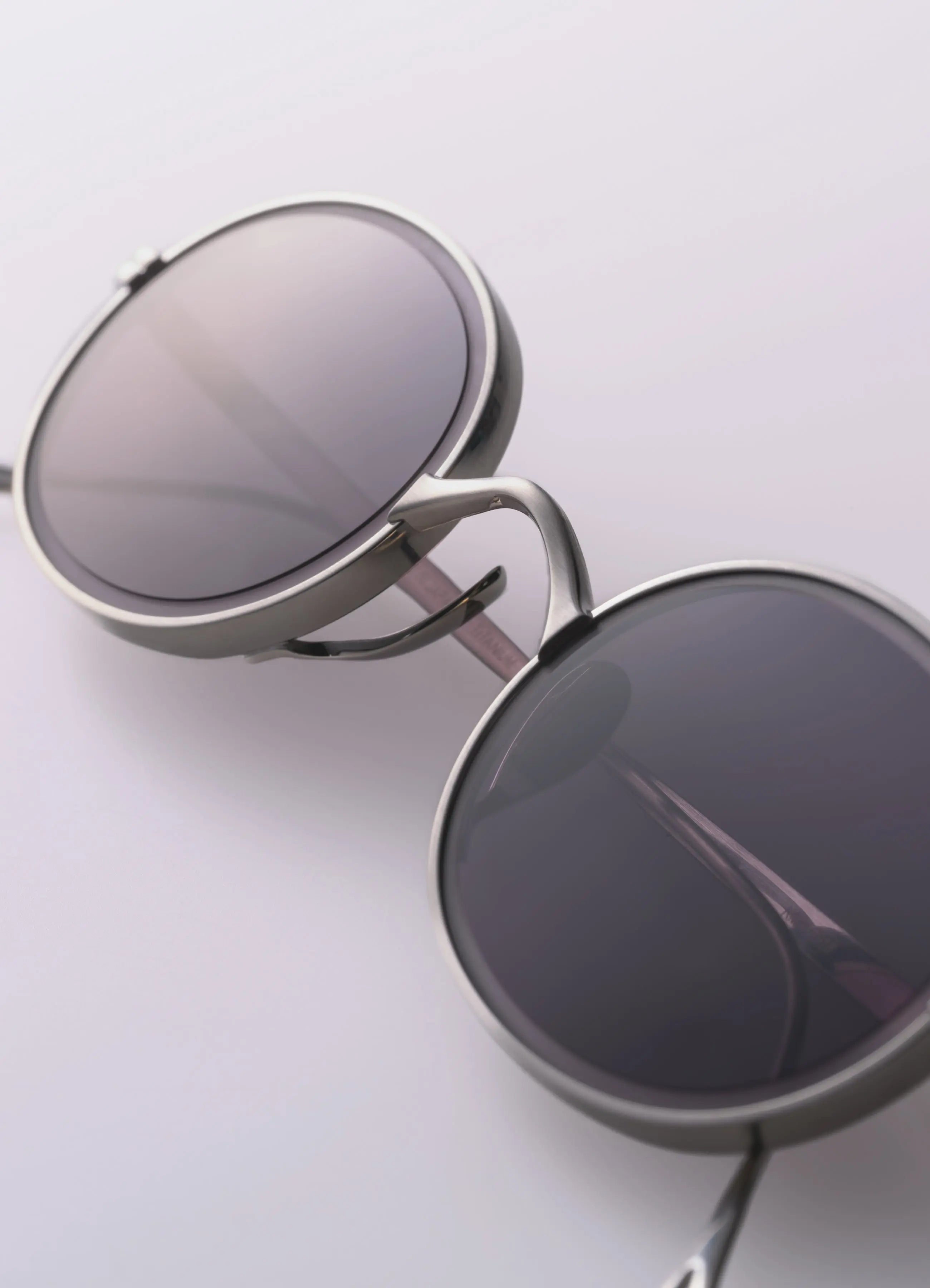 Round sunglasses with metallic frame on a light gray background