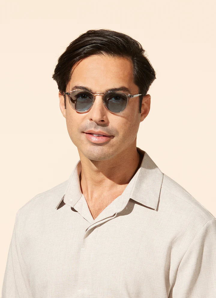 Man wearing sunglasses against a beige background
