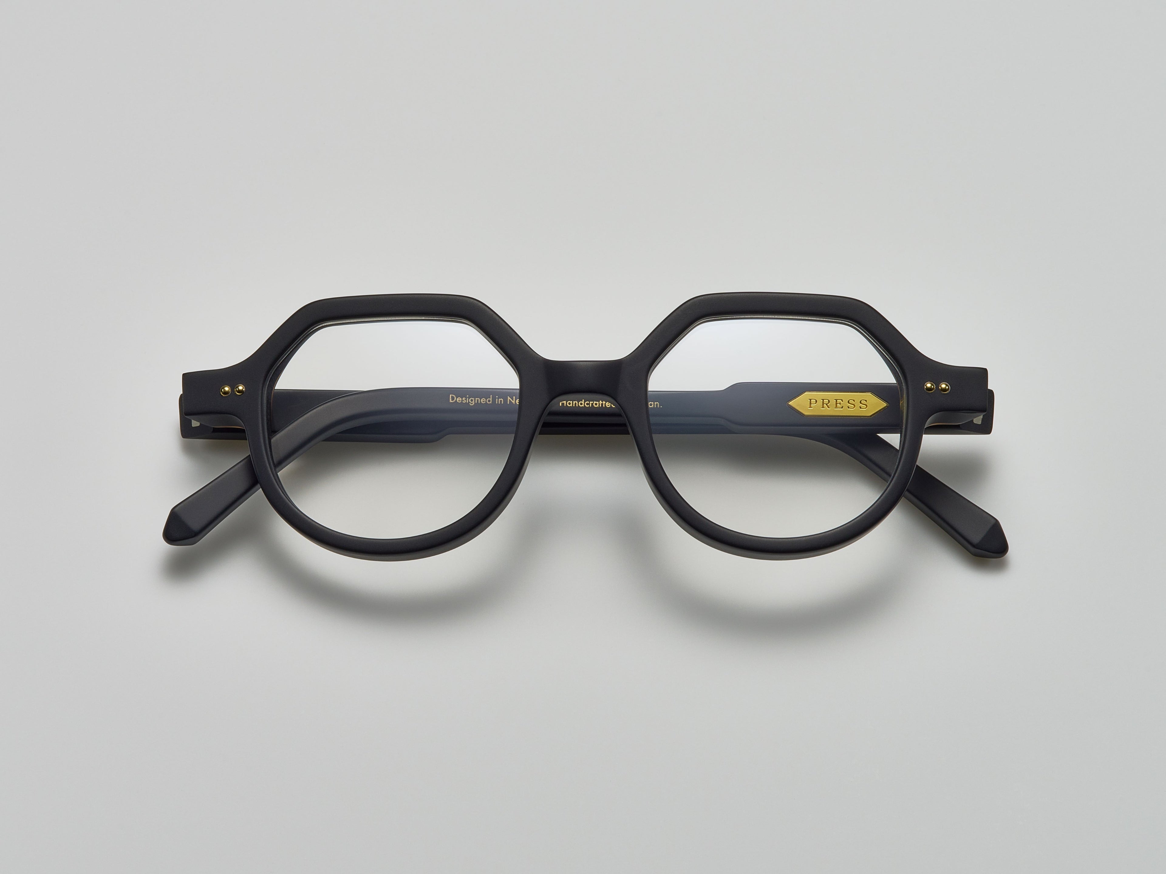 Mate black acetate eyeglasses with round and subtly geometric frames, featuring the brand name "PRESS" on the temple, by Yosemite Eyewear