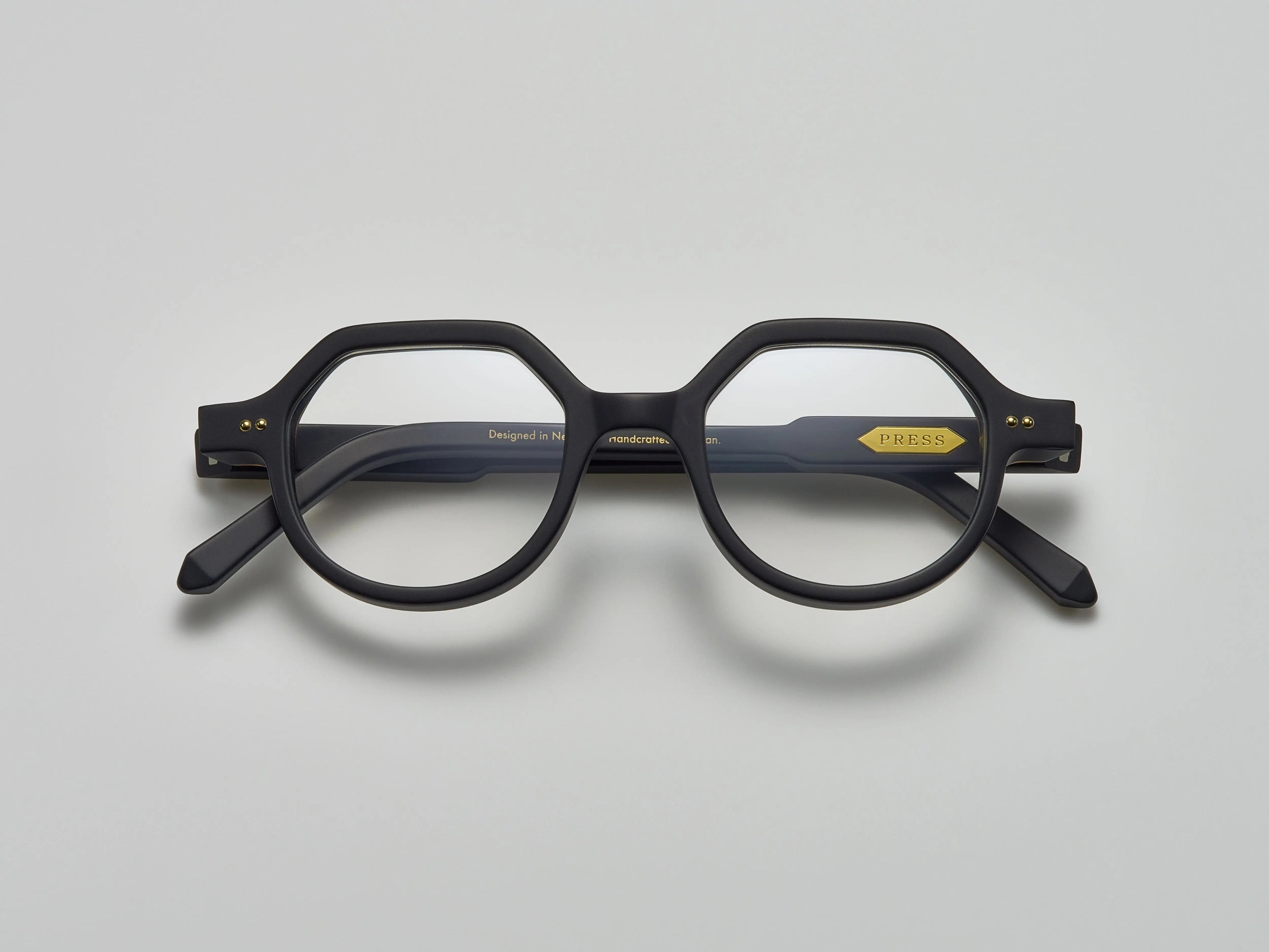 Mate black acetate eyeglasses with round and subtly geometric frames, featuring the brand name "PRESS" on the temple, by Yosemite Eyewear