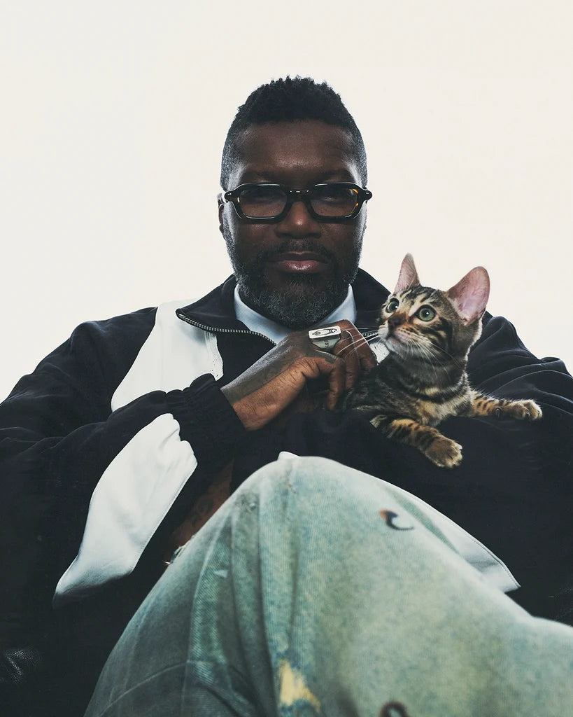 Man wearing Paloceras Leopard Lace S2 eyeglasses, holding a kitten