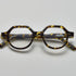 Tortoiseshell acetate eyeglasses with round and subtly geometric frames, featuring the brand name "PRESS" on the temple, by Yosemite Eyewear