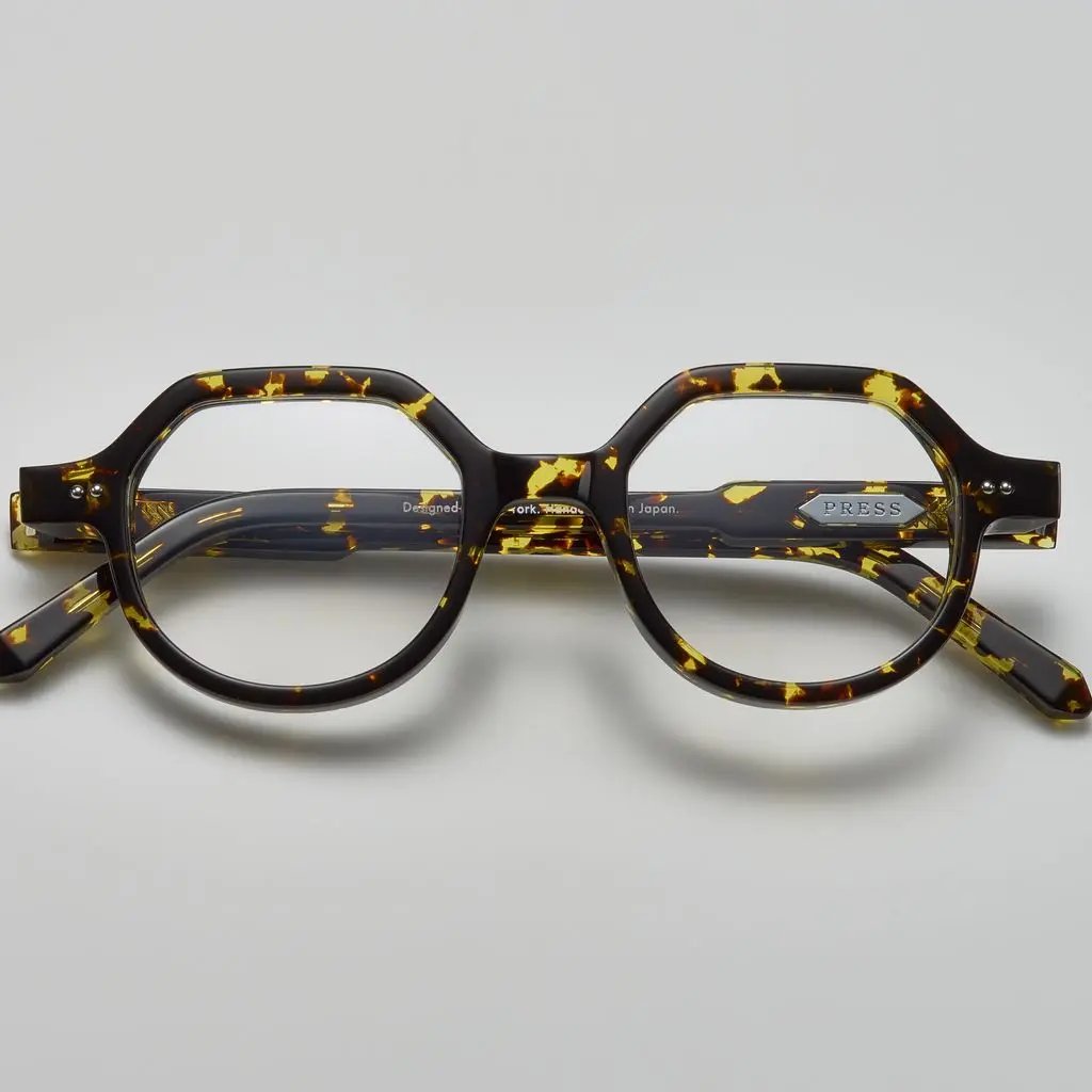 Tortoiseshell acetate eyeglasses with round and subtly geometric frames, featuring the brand name "PRESS" on the temple, by Yosemite Eyewear