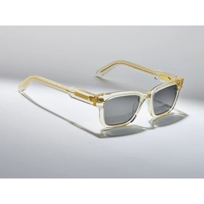 Sunglasses with gold frame and clear arms on a gray background