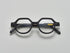 Mate black acetate eyeglasses with round and subtly geometric frames, featuring the brand name "PRESS" on the temple, by Yosemite Eyewear